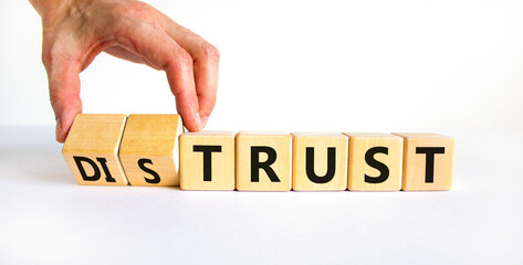 Distrust or trust symbol. Businessman turns wooden cubes, changes words 'distrust' to 'trust'....