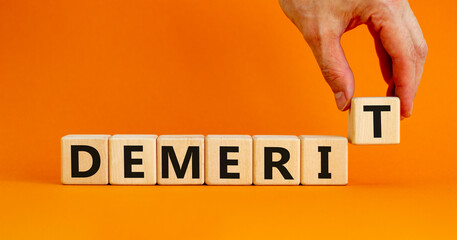 Demerit symbol. The concept word Demerit on wooden cubes. Beautiful orange table, orange...