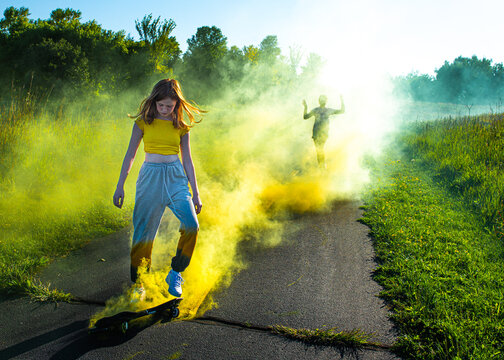 Happy tween girl skateboarding with smokebomb.