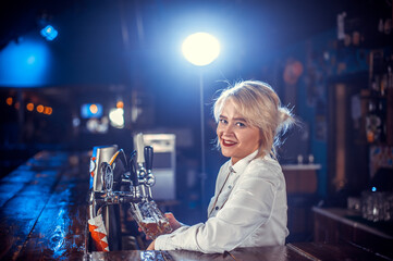 Girl barman makes a cocktail on the alehouse