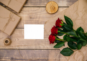 Naklejka na ściany i meble Invitation or postcard empty space for text. Festive atmosphere, red roses, on a wooden background.