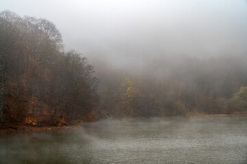 Obraz na płótnie Canvas Fog covers the forest by the blue lake in Kabardino-Balkaria.