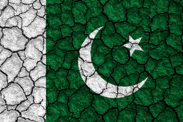 Islamic Republic of Pakistan flag on dry earth ground texture background