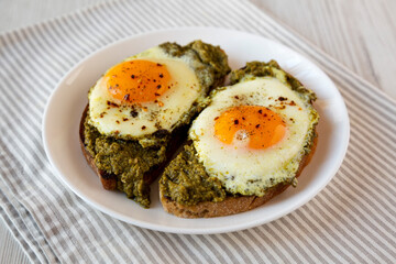 Homemade Pesto Egg Toast on a white plate, side view.