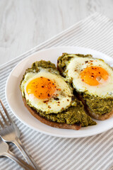 Homemade Pesto Egg Toast on a white plate, side view.