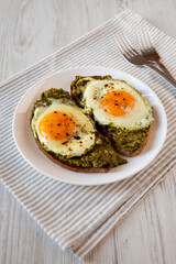 Homemade Pesto Egg Toast on a white plate, side view.