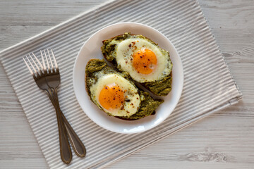 Homemade Pesto Egg Toast on a white plate, top view. Flat lay, overhead, from above.