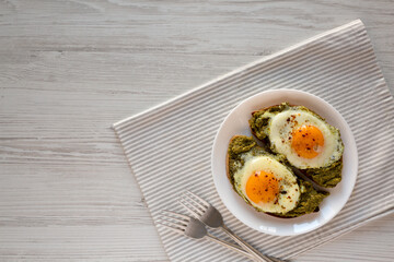 Homemade Pesto Egg Toast on a white plate, overhead view. Flat lay, top view, from above. Copy space.