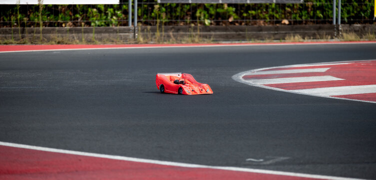 Radio wave controlled model car racing on asphalt racetrack
