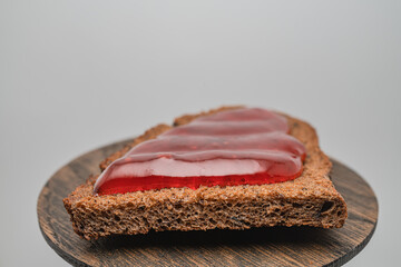 Rye bread toast with strawberry jam on a wooden tray