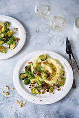 Brussels sprouts with pistachios, raisins and Skordalia (mashed potatoes). Healthy Meal preparation. Plant-based dishes. Green living. Vegan recipe. Food styling. Vegetarian cuisine