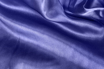 Color of the year 2022 elegant smooth silk or satin folds closeup. Cloth texture background. Abstract wallpaper. Trendy violet backdrop for web design. Luxury twisted fabric backplate