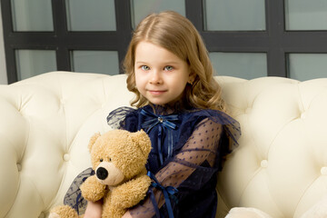 Lovely little girl hugging her teddy bear toy