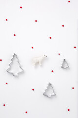 Minimal New Year composition polar bear among Christmas trees and red winter berries. New year concept. Gift wrapping pattern 