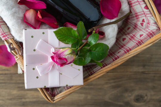 Valentine's Day. Gift basket with bottle, gift box and rose. Copy space.