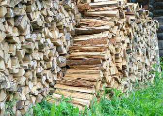 The split firewood is stacked in a woodpile.