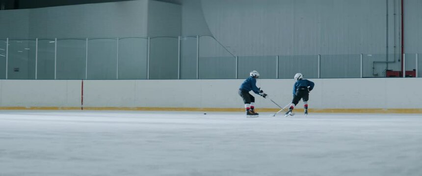 Coach Is Watching The Kids Ice Hockey Practice Inside Indoor Rink. Shot With 2x Anamorphic Lens