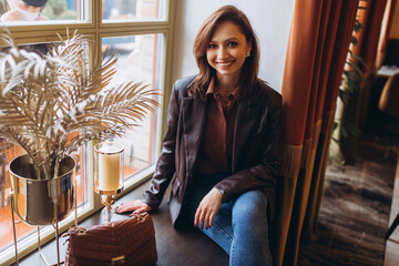 Stylish young brunette woman in cafe smiling 