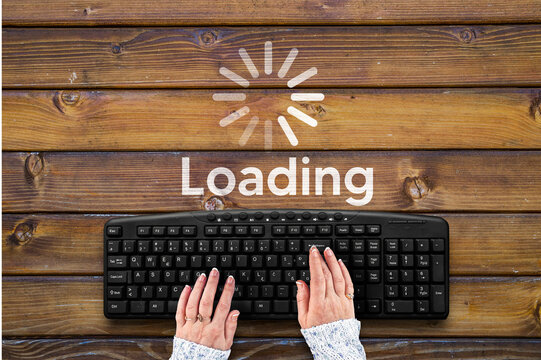 woman hands on pc keyboard  and loading bar on wooden desk
