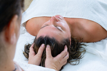 Energetic massage on the head of woman