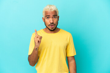 Young Colombian handsome man isolated on blue background intending to realizes the solution while...