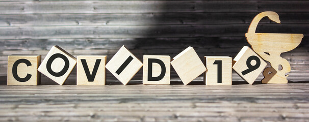 World pandemic virus COVID 19 word on wooden blocks with brown background