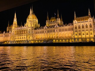 Fototapeta premium Illuminated Parliament building of Budapest at night with dark sky and reflection in Danube river