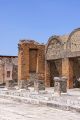 Ruins of an ancient city destroyed by the eruption of the volcano Vesuvius in 79 AD near Naples, Pompeii, Italy. Portico in front of the entrance to the Macellum - obrazy, fototapety, plakaty
