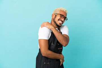 Restaurant Colombian waiter man isolated on blue background suffering from pain in shoulder for having made an effort