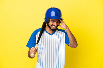 Young Colombian latin man playing baseball isolated on yellow background laughing