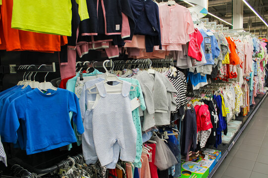 lot of children's clothes perspective photo hanging in order on a hanger in a clothing row for sale in a shopping center