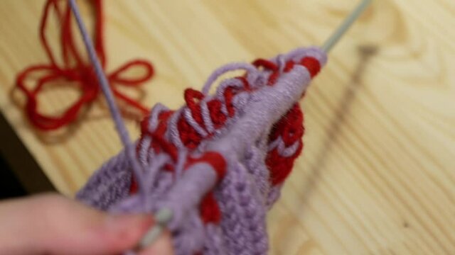 Knitting.
Man knits a sweater using knitting needles.