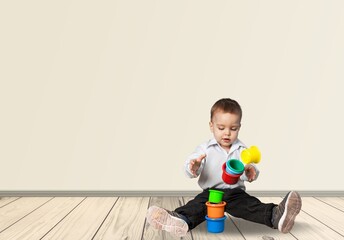 Naklejka premium Baby plays with educational toys on the floor. Toddler