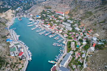 Aerial view of Balaklava Bay in Crimea with many berths with boats. Shooting from a drone.