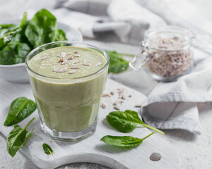 Glass of homemade healthy green smoothie with fresh baby spinach