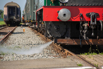 Fototapeta premium steam coming out of steam train riding on tracks. detailed shot