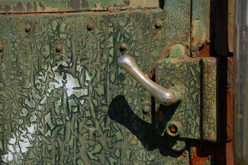 Weathered green paint and handle of train door