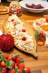Christmas dinner with potato salad and cherries table set with pretty plate