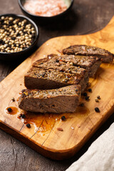 Fototapeta na wymiar A piece of cooked beef meat steak on wooden board cut in slices