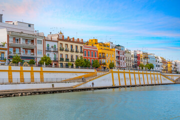 Colorful buildings including homes and shops face the Guadalquivir River in the Triana District of the Analusian city of Seville, Spain.