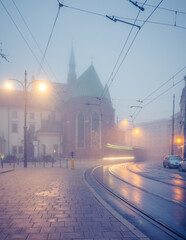 Picturesque old town Franciszkanska street and St Francis church on foggy morning, Krakow, Poland