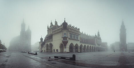 Krakow, Poland, main square panorama with Cloth Hall and St Mary's church on foggy November morning - 474274843