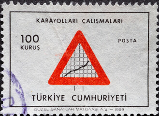 Turkey - circa 1969: A post stamp printed in Turkey showing a traffic sign with a warning slope