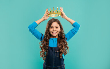 happy teen girl with curly hair wear crown on blue background, egoist