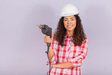 afro woman holding an electric drill on white background.