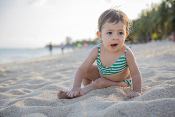 Fototapeta na wymiar emotional surprised little girl at sandy beach