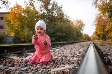 adorable girl sit on railroad autumn day