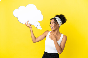 Young african american woman isolated on yellow background holding a thinking speech bubble and pointing it