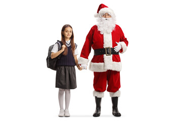 Full length portrait of santa claus holding hand of a girl in a school uniform with a backpack