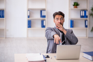 Obraz premium Young male employee working in the office